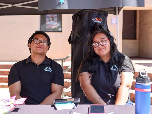 Two students smiling while tabling at Club Rush event