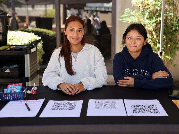 Two students sitting at their club's table during Club Rush