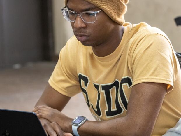 A student uses his laptop between classes