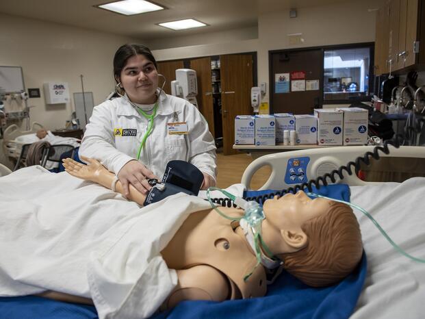 A psych tech student works with a mannequin