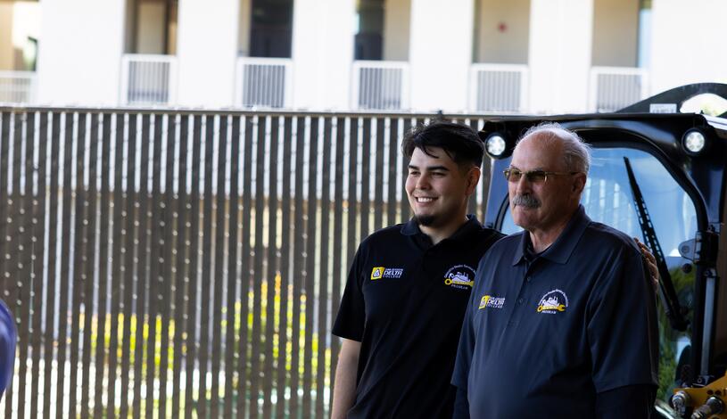 A Caterpillar student stands with his instructor
