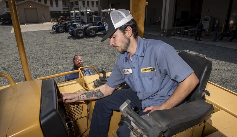 A Caterpillar student operates heavy equipment