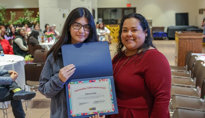 A student smiles after being recognized for her achievements.