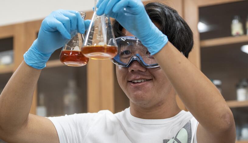 A student measures chemicals in chem lab