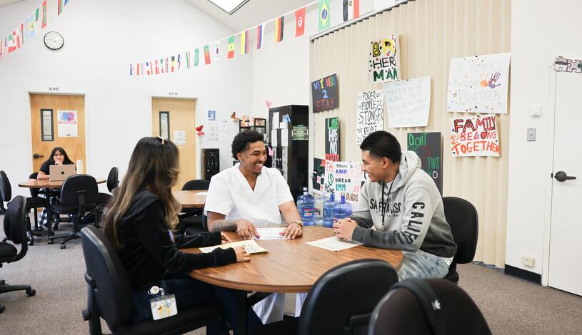 Students talk at a table in the Dreamers Success Center
