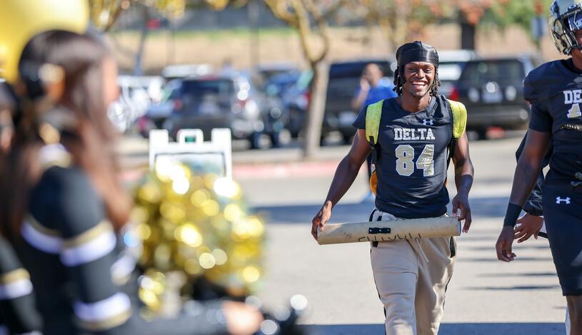 A Mustang football player smiles as he arrives at the new football field.