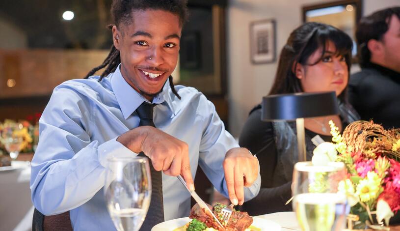 Photo of a student eating dinner at the Student Chef during a professional mixer event