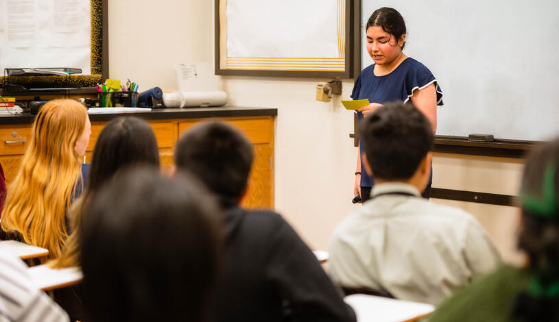 A student reads her speech during a communications class