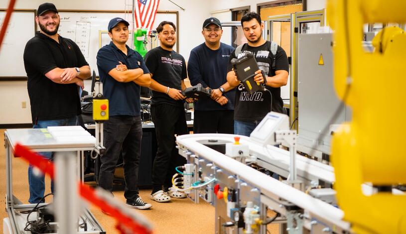 A group of robotics students smiles for the camera