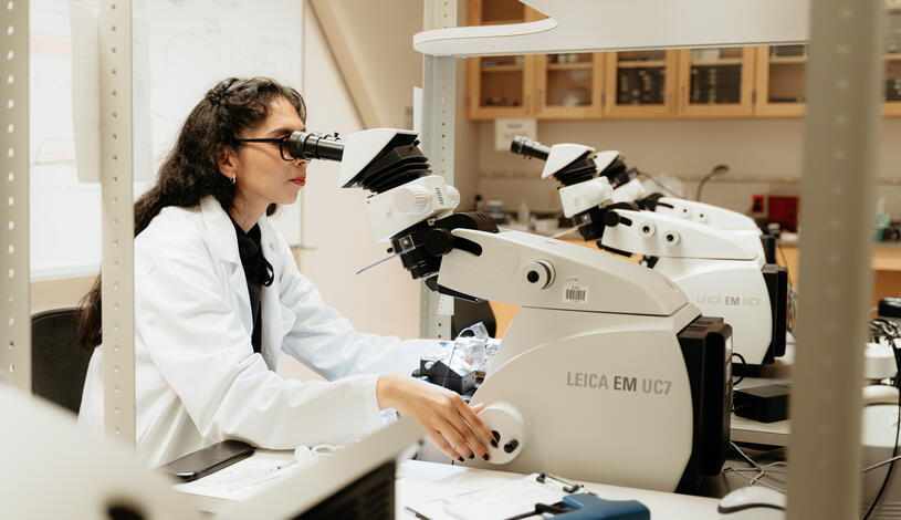 Photo of a student using an microscope.