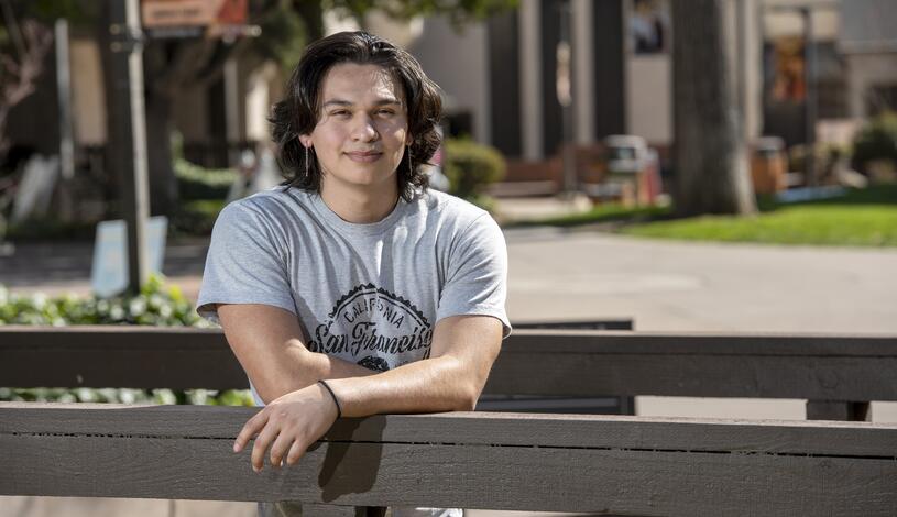 A student poses for a photo on the Delta College bridge near the Quad