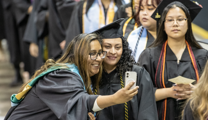 A Delta College student poses with a counselor at Commencement