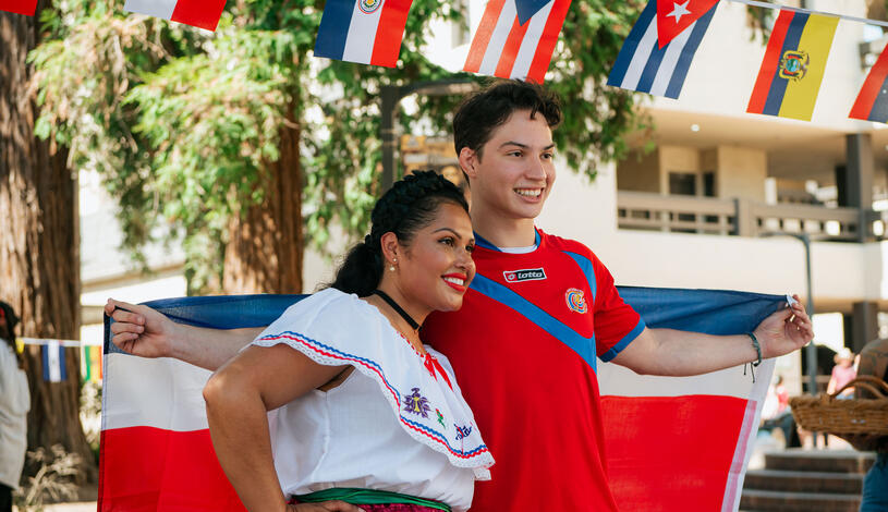 A student and faculty member hold a flag