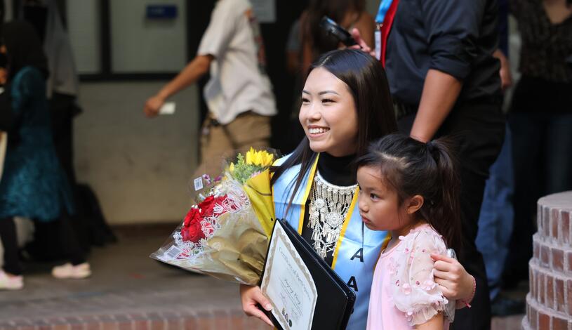 Photo of a Delta graduate smiling with her daughter