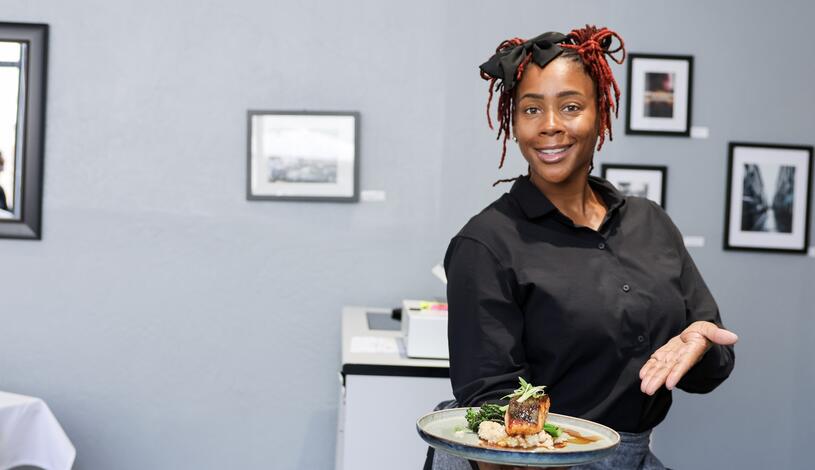 Photo of a student serving food at the Student Chef