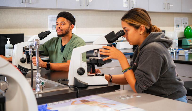 Photo of two students using microscopes at Delta's Mountain House campus