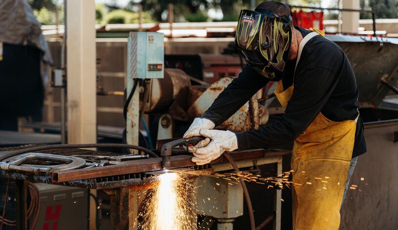 Photo of a welding student with sparks flying