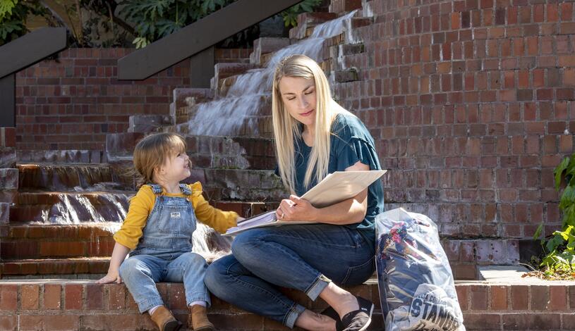 Photo of a student parent and her daughter studying at Budd