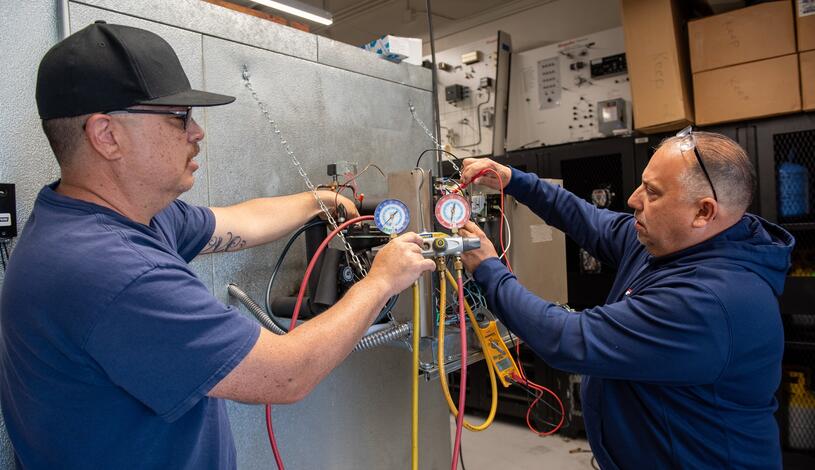 Photo of two HVAC students working on a project