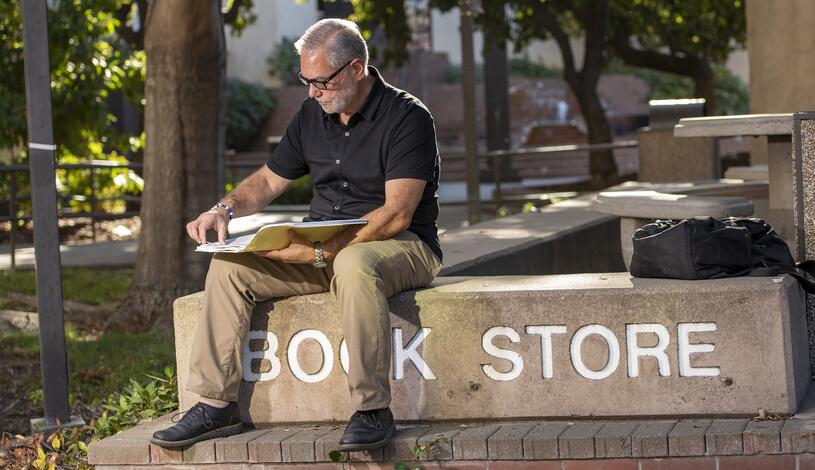 Student reading book in front of Bookstore