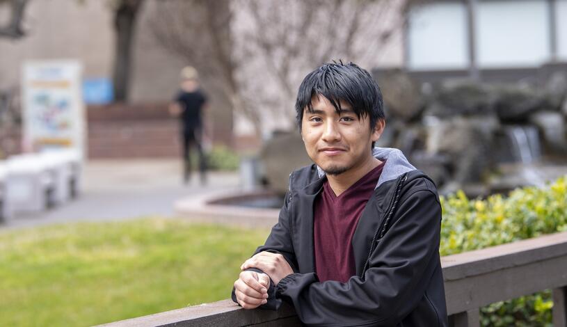 Photo of a student standing on the bridge near the Quad