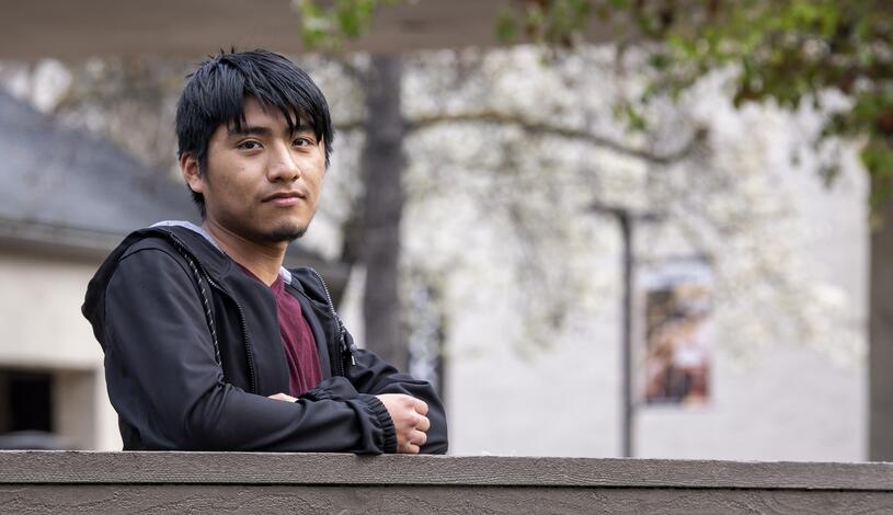 Photo of a student standing on the bridge near the Quad