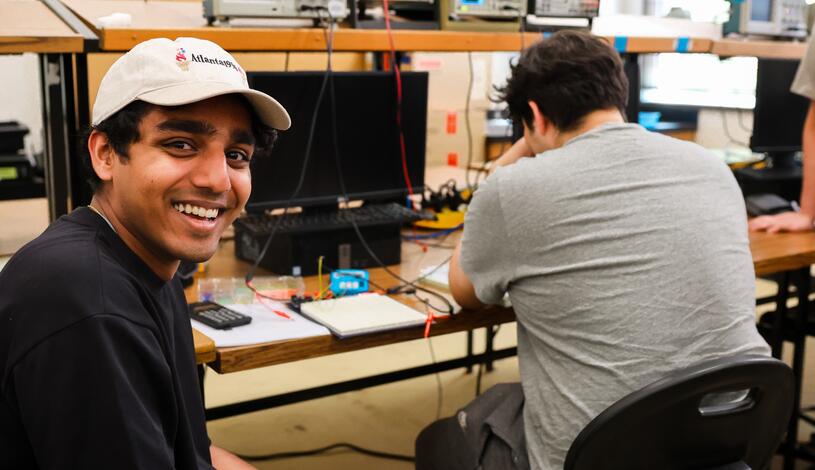An electronics technology student smiles for the camera