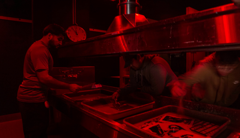 Photo of a student using the dark room in the photo lab