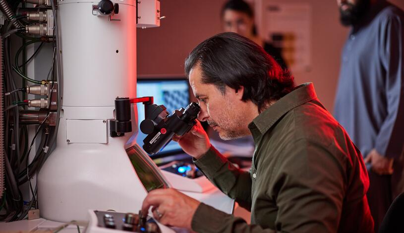 Photo of a student using an electron microscope