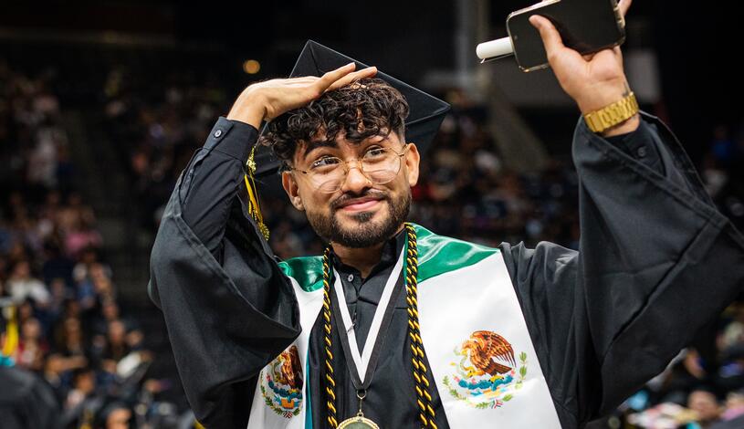 Photo of a student looking toward his family during Commencement