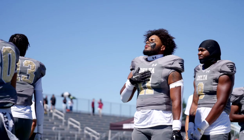 Photo of a Delta College football player with hand over heart