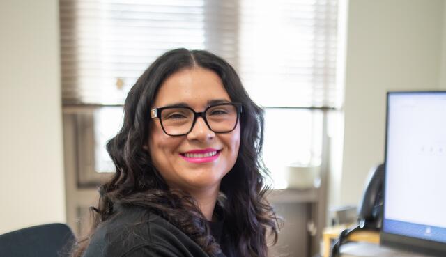 Counselor sitting at desk and smiling