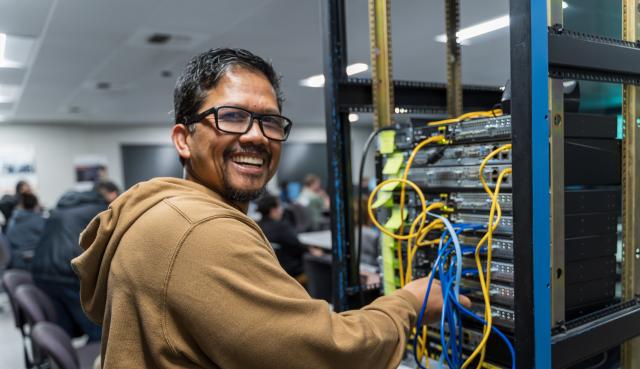Student smiling while working on CISCO Networking project
