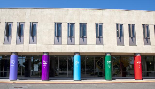 Wide angle view of the exterior of the Delta Connect Center highlighting the TrAC pole banners in various colors