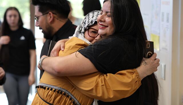 Photo of a student getting a hug from a Delta employee after her graduation celebration