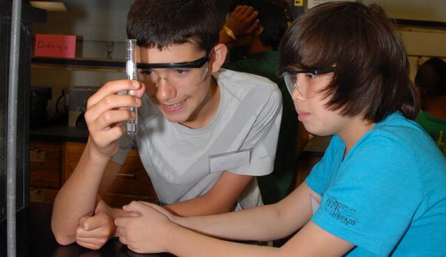 Two young boys looking at a testtube