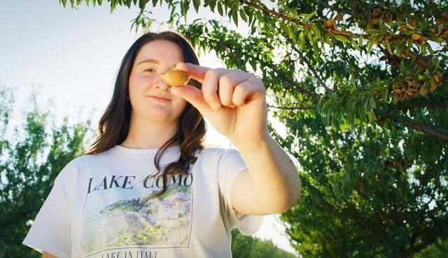 Photo of an agriculture student holding an almond