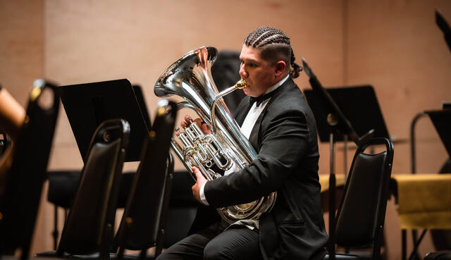 A student musician plays the baritone in band