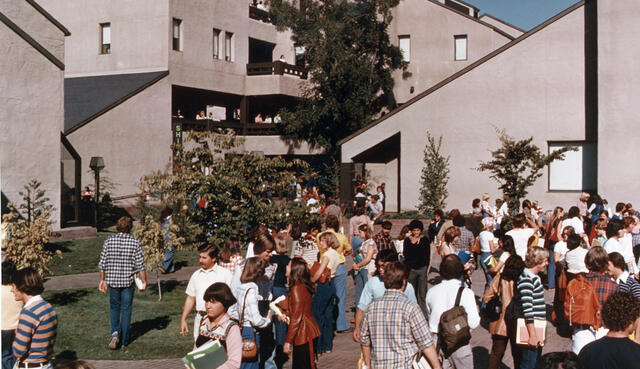 Students outside on campus walking to class in 1977