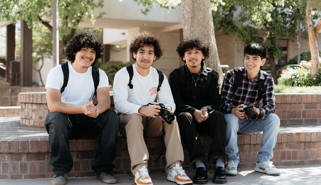 Photo of four students hanging out in the Quad