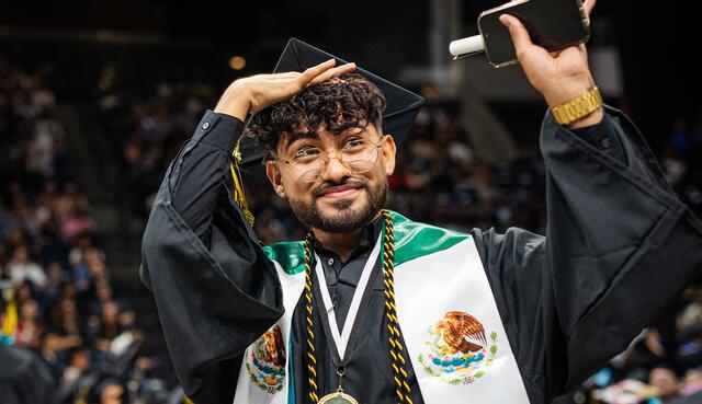 Photo of a student looking toward his family during Commencement