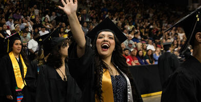 A Delta College graduate waves to her family