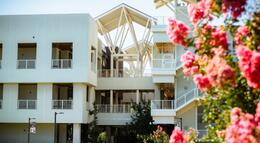 A photo of the Science and Math Building with beautiful blossoms in the foreground