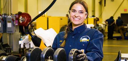Student standing with Diesel and Heavy Equipment smiling