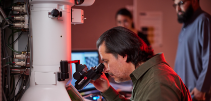 a person looking through the high-end microscopy
