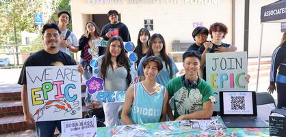 Students in the EPIC club hold signs in the Quad