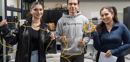 A photo of students posing with computer network wiring