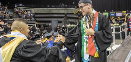 Photo of a student leaving the stage after Commencement
