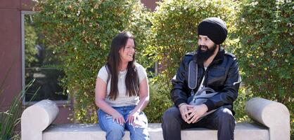 Students sitting on bench laughing