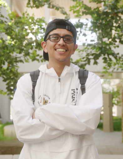 Student smiling with arms crossed